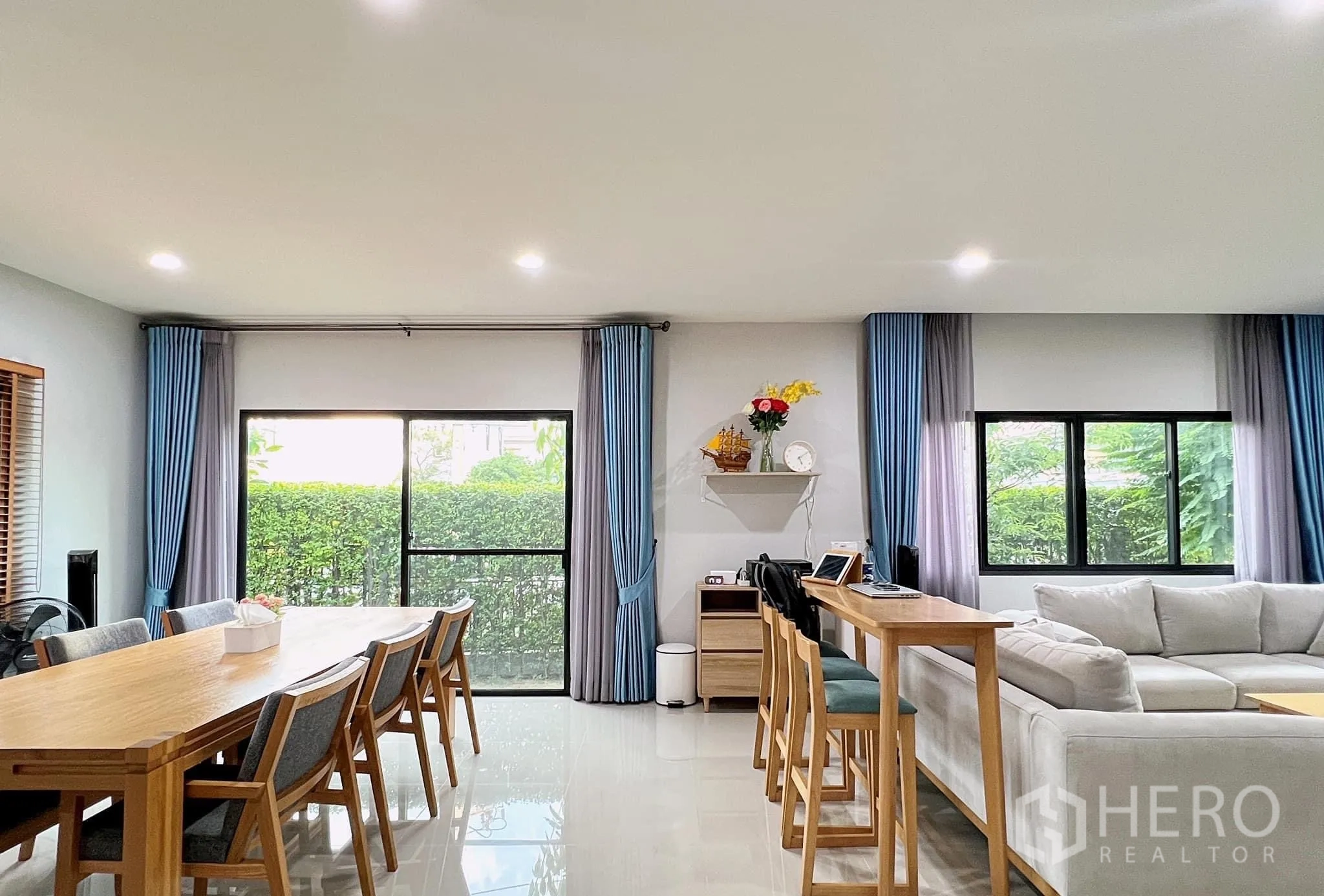 Detached House for rent or sale in Lam Luk Ka, Pathum Thani - Spacious ground floor with long dining table, breakfast bar and floor-to-ceiling windows.