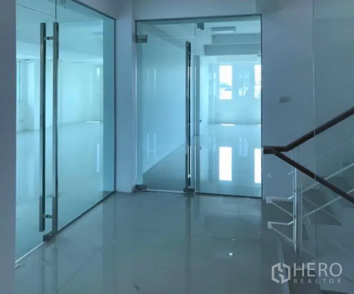 Office Space for rent in Wang Thonglang, Bangkok - Modern office corridor featuring floor‑to‑ceiling glass partitions and glossy tile floors.