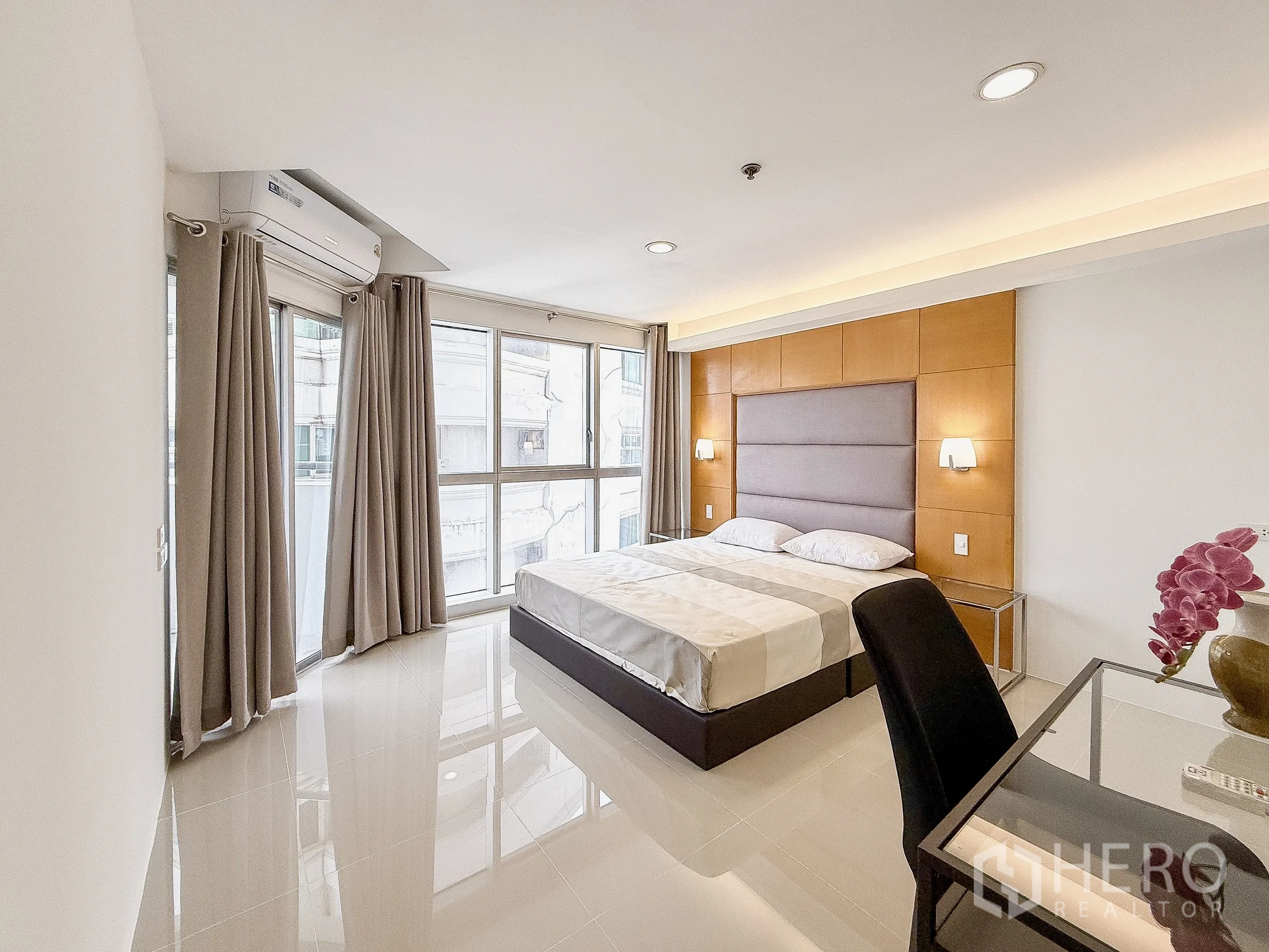 公寓 出租在Khlong Toei, Bangkok - 采光充足的卧室，书桌、转角窗与中性色窗帘。