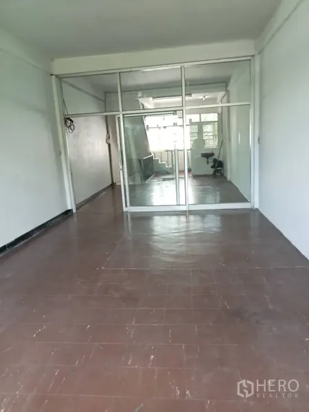 Shophouse for rent in Phra Khanong, Bangkok - Upper-floor room with brown tile flooring and a full-height glass partition near the staircase.