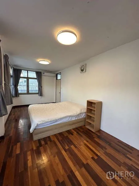 Home Office for rent in Din Daeng, Bangkok - Bedroom with polished wood flooring, double bed, windows with curtains and ceiling lights.