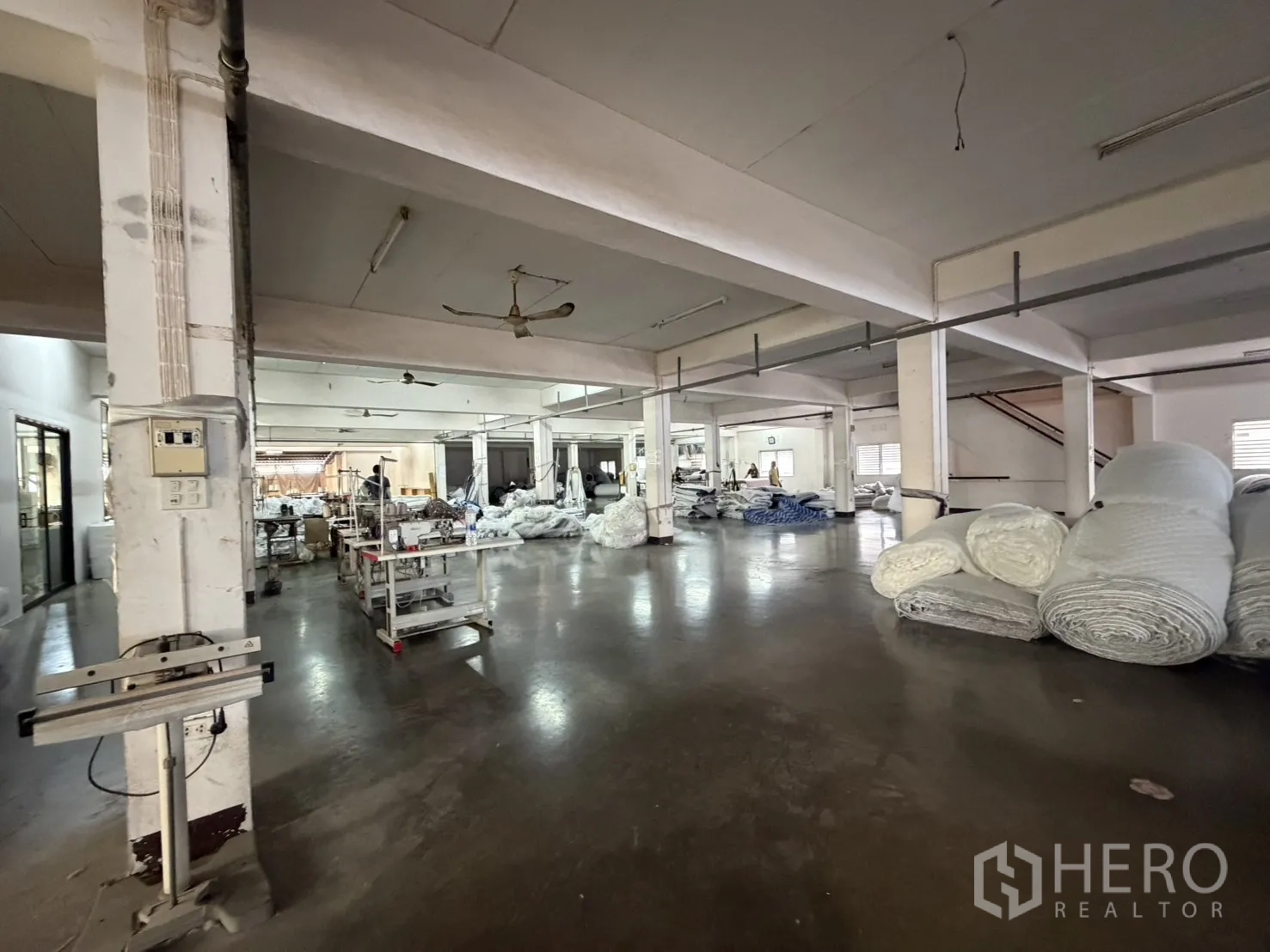 工厂 for rent or sale in Bang Bon, Bangkok - 生产车间，缝纫工位、工作台与卷材。