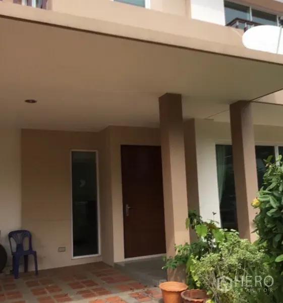 บ้าน ให้เช่าในBang Phli, Samut Prakan - เฉลียงหน้าบ้านมีเสาและต้นไม้ นำสู่ประตูทางเข้าหลัก
