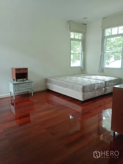 Detached House for rent in Bang Rak, Bangkok - Spacious bedroom with twin mattresses and ample natural light.