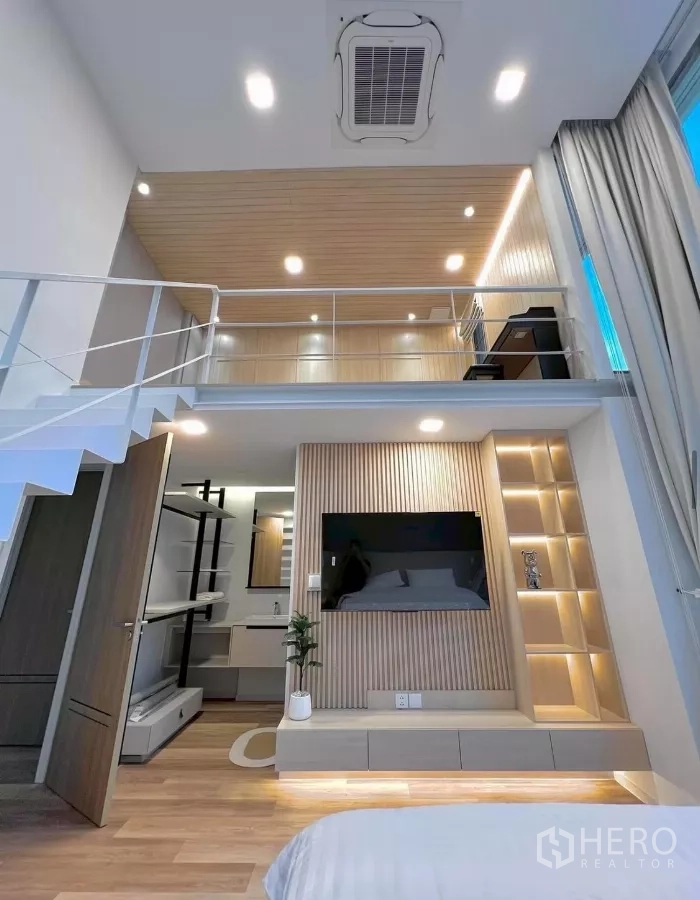 Detached House for rent in Saphan Sung, Bangkok - Bedroom with double‑height ceiling and mezzanine workspace, built‑ins and ensuite vanity.