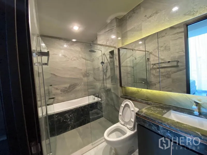 คอนโด ให้เช่าในWatthana, Bangkok - ห้องน้ำหรูหราปูกระเบื้องลายหินอ่อน พร้อมฝักบัวกระจกกั้น อ่างอาบน้ำ และเคาน์เตอร์อ่างล้างหน้าไฟส่องสว่าง