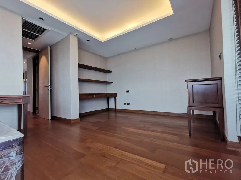 Condominium for rent or sale in Phaya Thai, Bangkok - Flexible room with wood flooring, built-in shelves and desks, and recessed ceiling lighting.