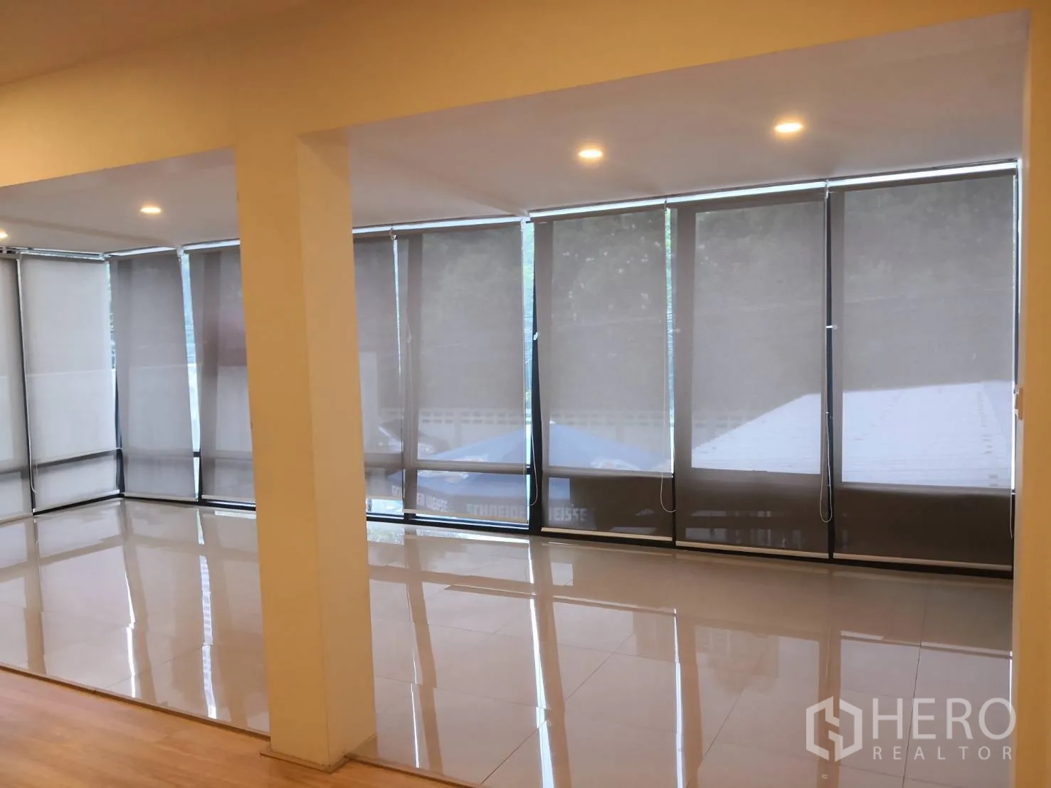 Detached House for rent in Watthana, Bangkok - Corner living space with wraparound floor-to-ceiling windows and polished tile flooring.