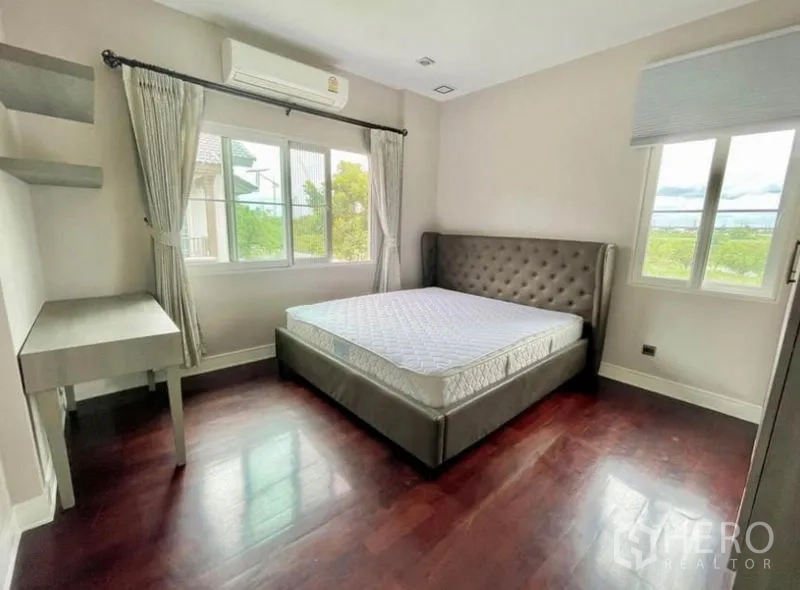 独立式住宅 出租在Bang Phli, Samut Prakan - 采光充足的卧室，转角窗、空调与木地板。