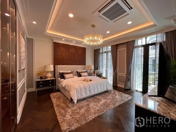 Detached House for sale in Yan Nawa, Bangkok - Spacious master bedroom with chandelier, balcony doors and a plush rug.