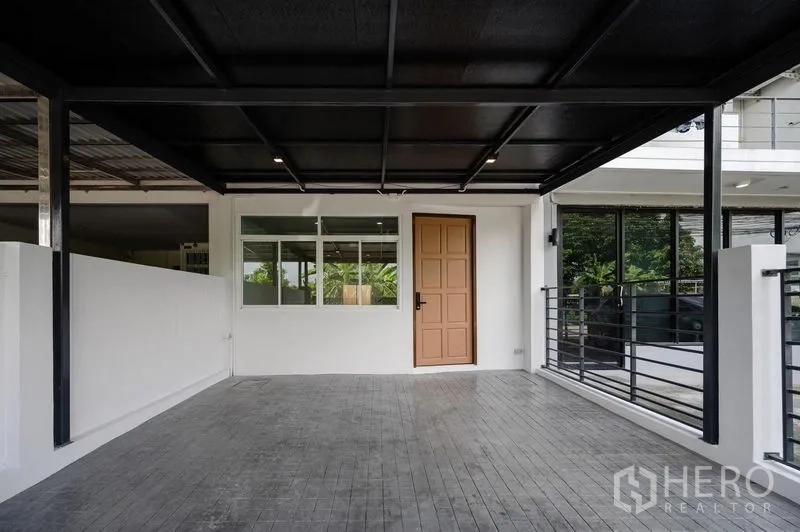 联排别墅 出售在Lat Phrao, Bangkok - 前院有顶停车位，入户门与窗户。