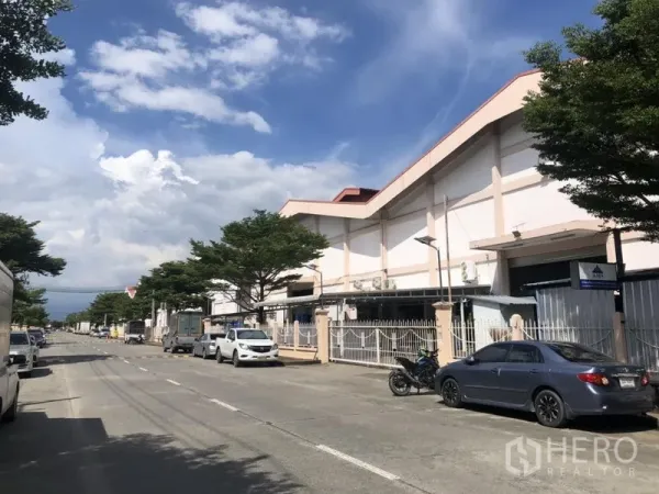 คลังสินค้า ให้เช่า - ถนนภายในโครงการอุตสาหกรรม ด้านหน้าโกดัง มีรถจอดและต้นไม้ให้ร่มเงา
