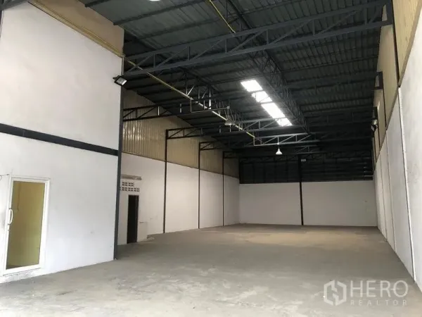 货栈 出租在Pak Kret, Nonthaburi - 开阔仓库空间，挑高天花、采光带和混凝土地面。