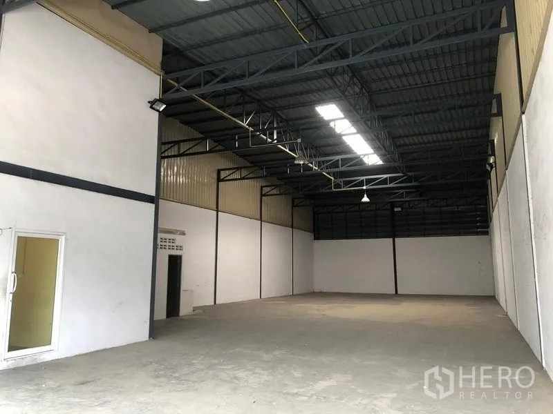 货栈 出租在Pak Kret, Nonthaburi - 开阔仓库空间，挑高天花、采光带和混凝土地面。