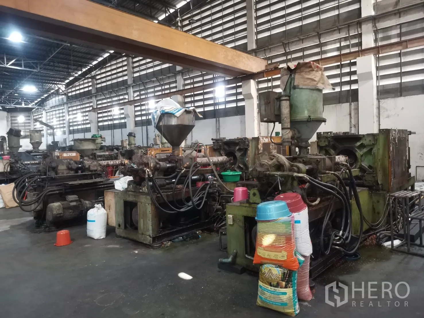 工厂 出租或出售在Bang Khun Thian, Bangkok - 一排塑料注塑机位于天车梁下方。