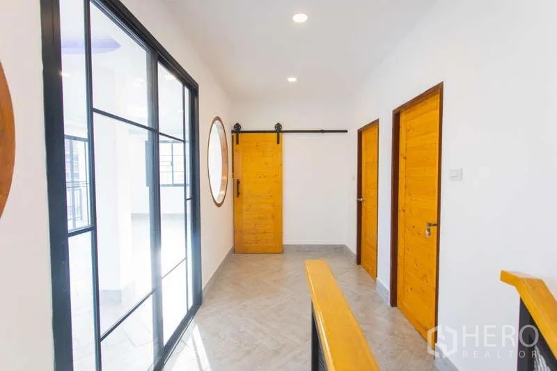 带办公室的家 出售在Huai Khwang, Bangkok - 二层走廊，木门、谷仓滑门与玻璃墙通向阳台。