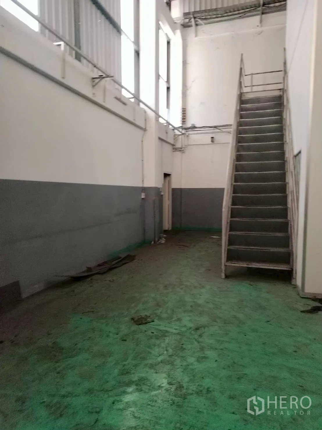 工厂 for sale in Bang Phli, Samut Prakan - 工业空间内的金属楼梯通往上层，墙面配有高窗采光。