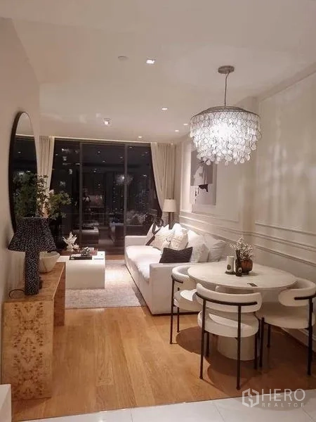 Condominium for sale - Cozy lounge and dining corner at night with pendant light and sofa by floor-to-ceiling windows.
