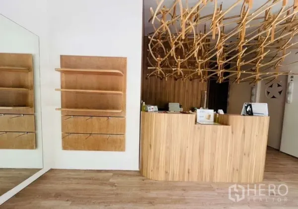 Retail Space for rent - Warm wood reception counter with decorative ceiling feature and wall shelving inside the retail space.