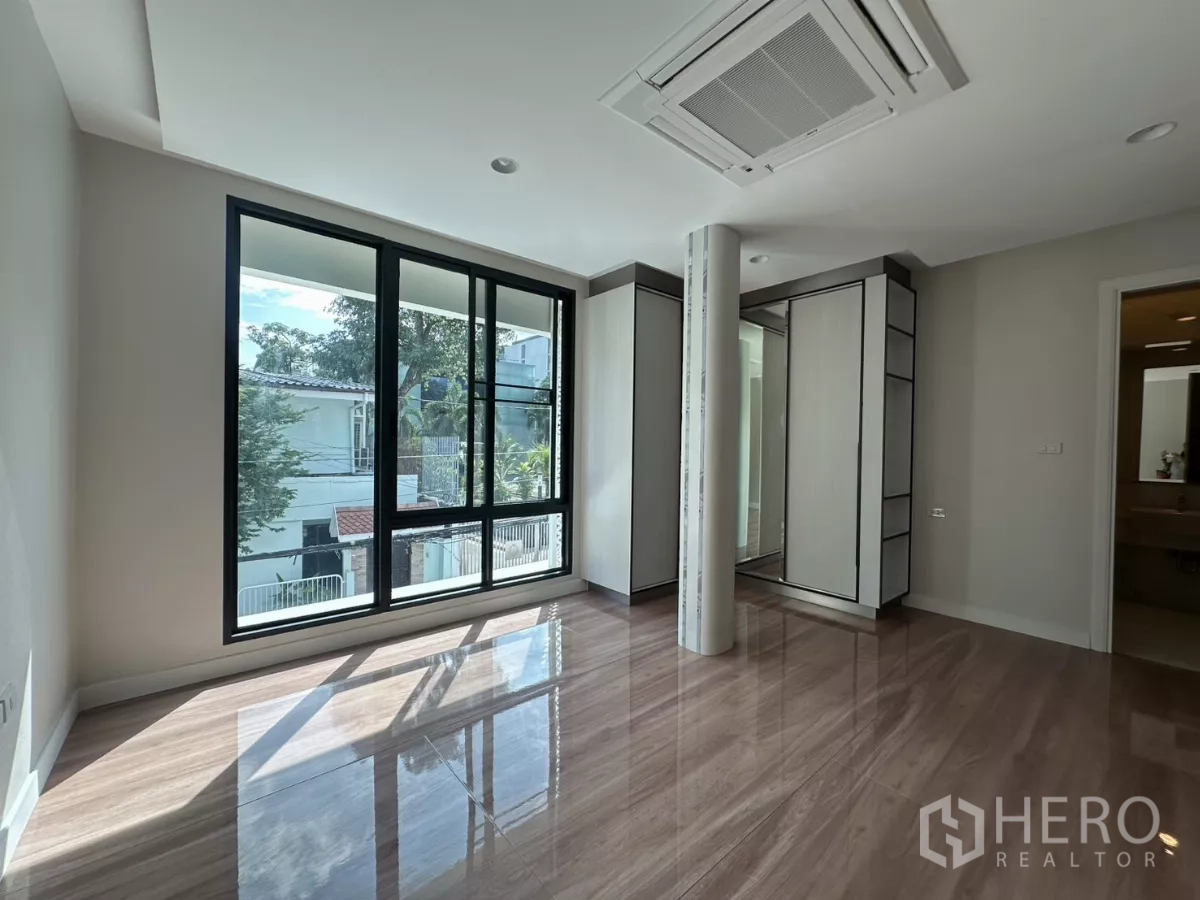 Townhouse for rent in Watthana, Bangkok - Large bathroom with glass-enclosed shower, marble tiles, and modern fixtures.
