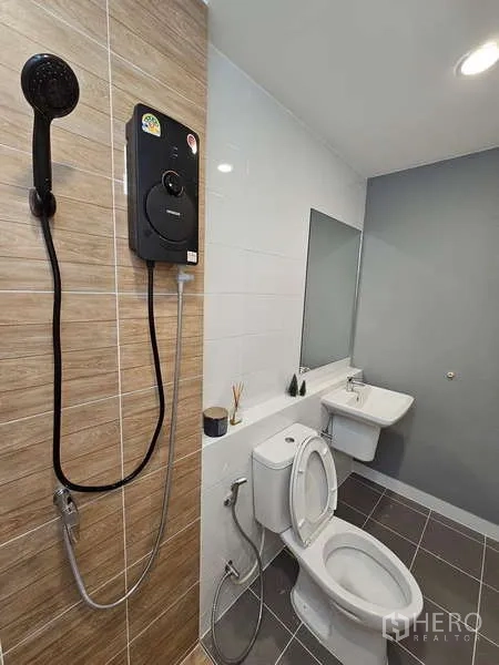 Townhouse for rent in Bang Phli, Samut Prakan - Clean bathroom featuring a wall‑mounted water heater, shower, toilet and sink with mirror.