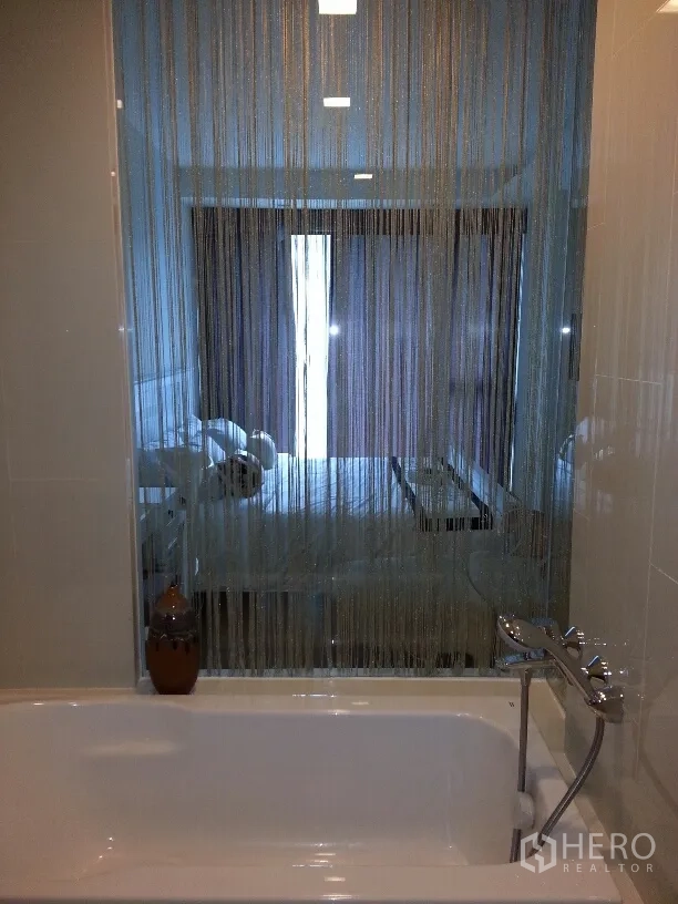 คอนโด ให้เช่าในWatthana, Bangkok - ห้องน้ำพร้อมอ่างอาบน้ำ ฝักบัวมือ และผนังกระจกมองเห็นห้องนอน
