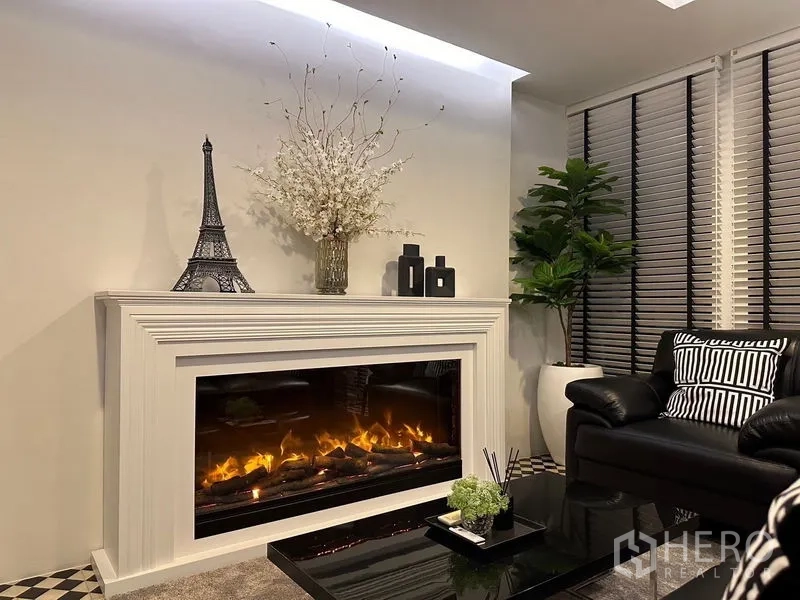 Detached House for rent - Close-up of a modern electric fireplace with mantel and decorative accents in the lounge.