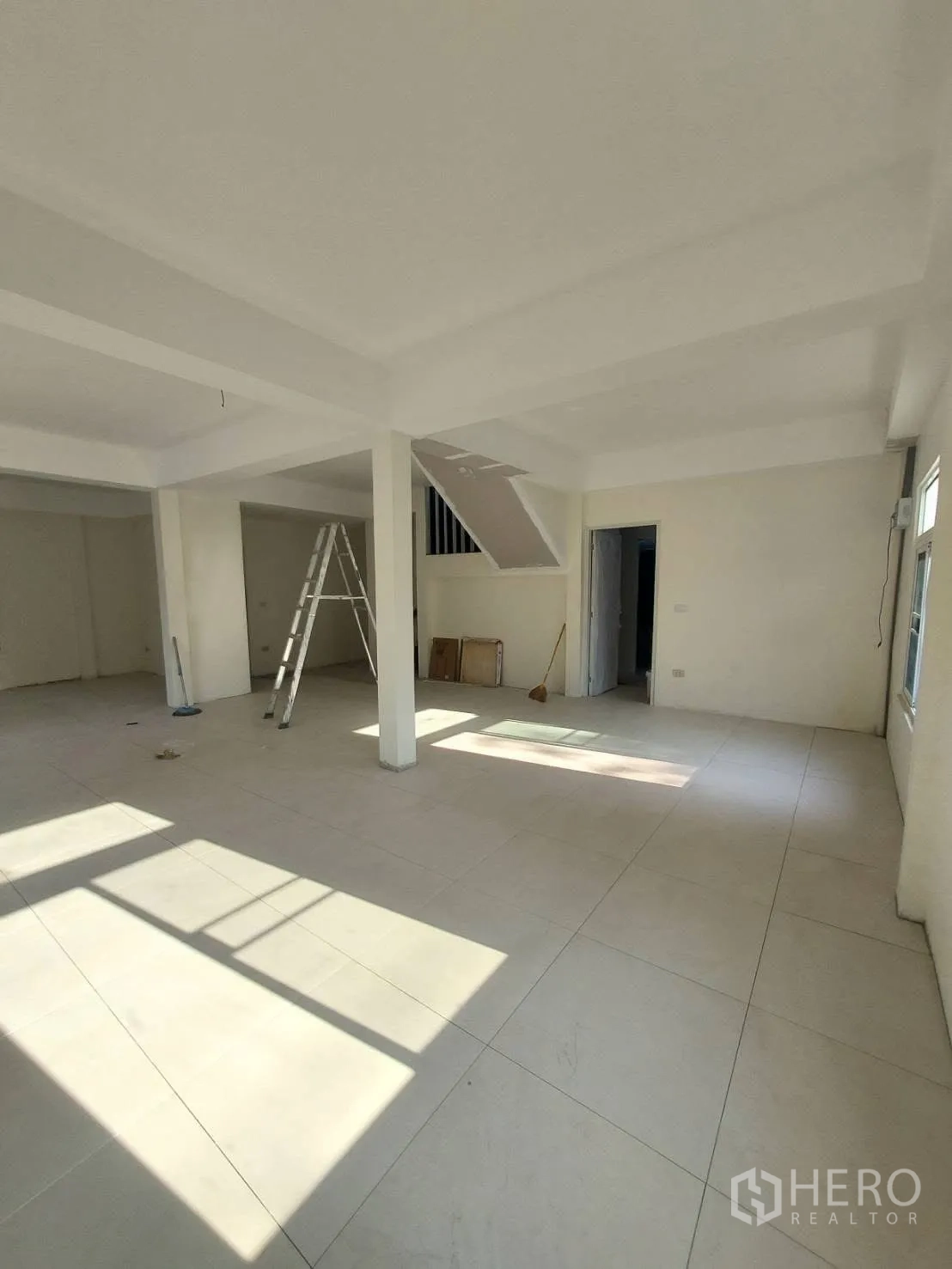 บ้านเดี่ยว for rent in Watthana, Bangkok - ห้องนั่งเล่นสว่างปูกระเบื้องแผ่นใหญ่และมีพื้นที่ใต้บันได.