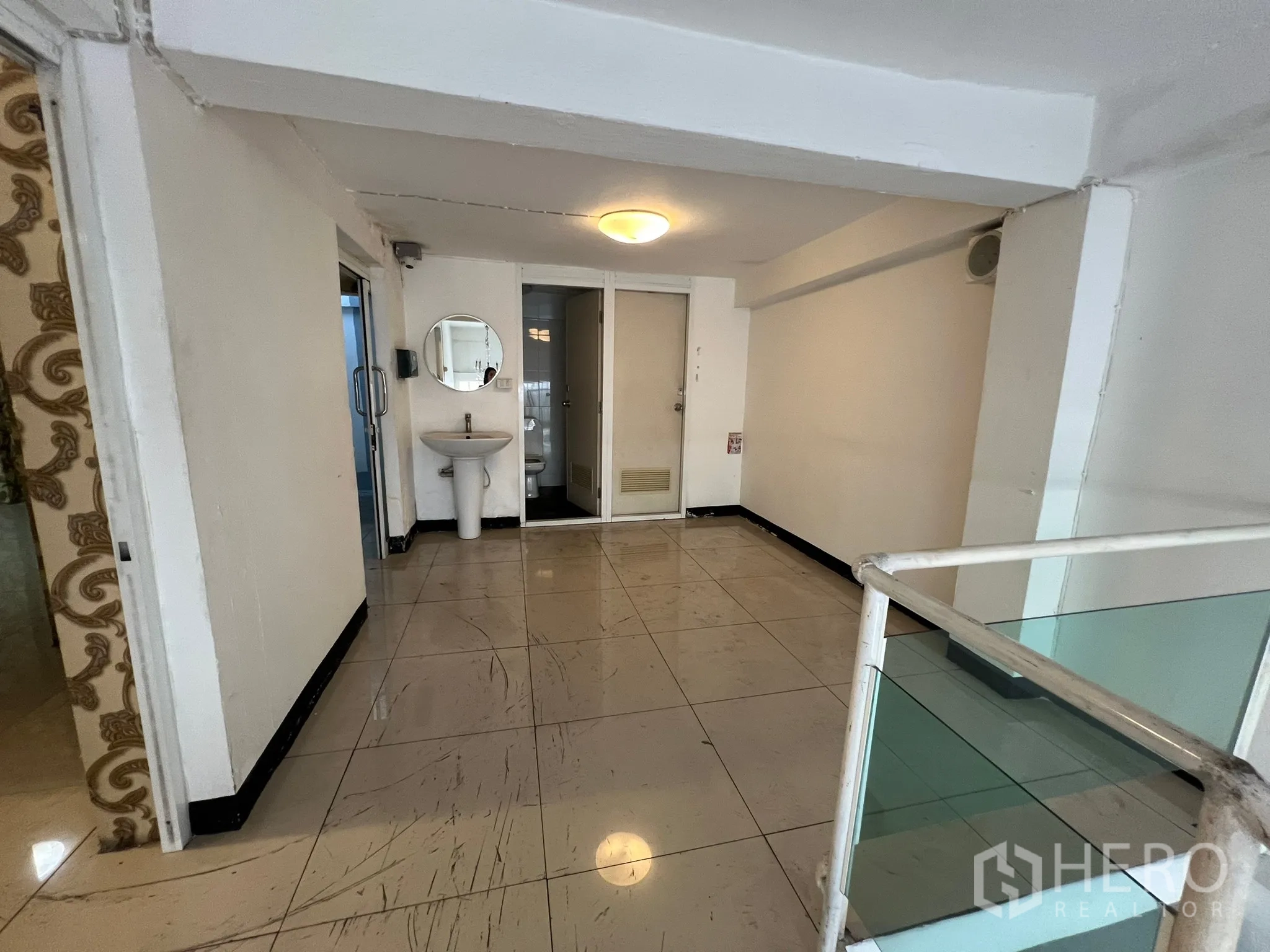 Shophouse for rent in Khlong Toei, Bangkok - Upper landing with tiled floor, sink and access to bathrooms beside the stairs.