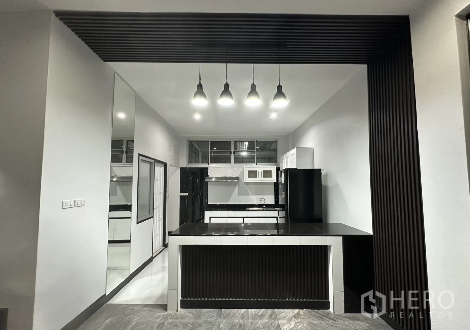 Home Office for rent in Khlong Toei, Bangkok - Kitchen island with pendant lights and slatted ceiling detail.