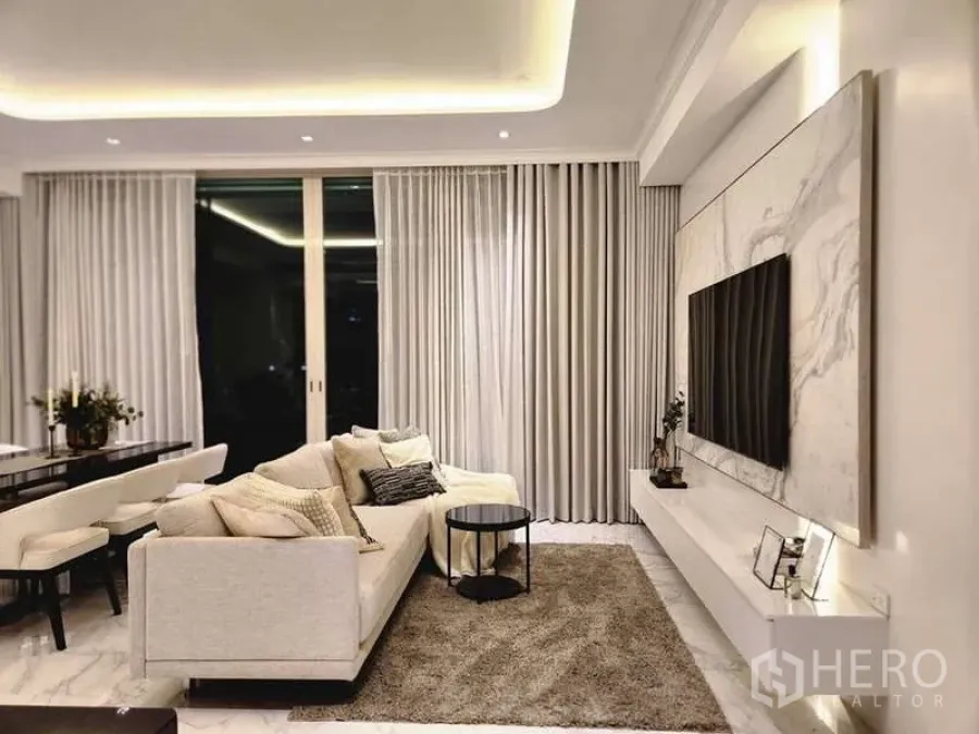 คอนโด ขายในWatthana, Bangkok - ห้องนั่งเล่นหรู ผนังทีวีลายหินอ่อน พรมผืนใหญ่ และประตูระเบียงบานเลื่อน