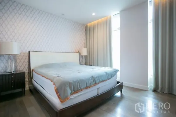公寓 出租在Pathum Wan, Bangkok - 宽敞主卧，特征墙、特大床与落地窗帘。