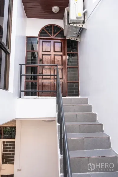 Home Office for rent in Khlong Toei, Bangkok - External staircase leading to an arched wooden entry door on upper level.