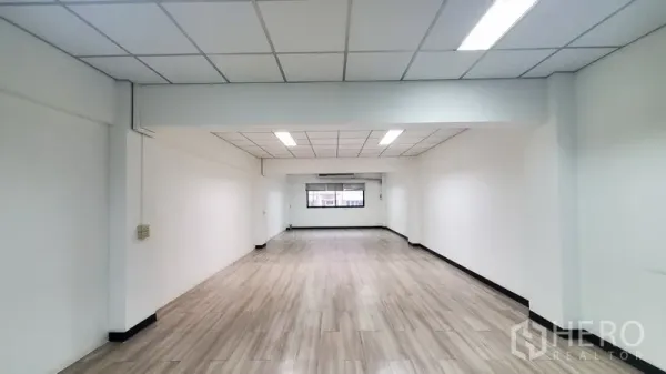 办公空间 出租在Khlong Toei, Bangkok - 明亮的开放式办公室，木纹地面、白墙、格栅吊顶LED灯、端部窗户与空调，位于素坤逸Phra Khanong一带。