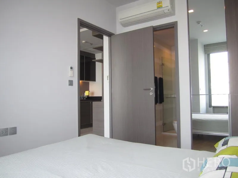 Condominium for rent in Khlong Toei, Bangkok - Cozy bedroom with air conditioning, mirrored wardrobe and direct access to the bathroom.