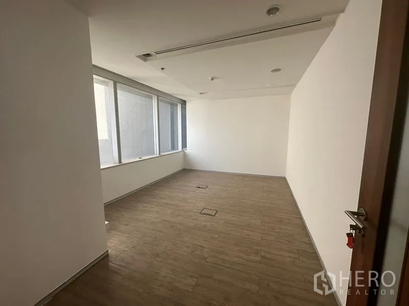 Office Space for rent in Khlong Toei, Bangkok - Bright small office with wood-look floors and side windows.