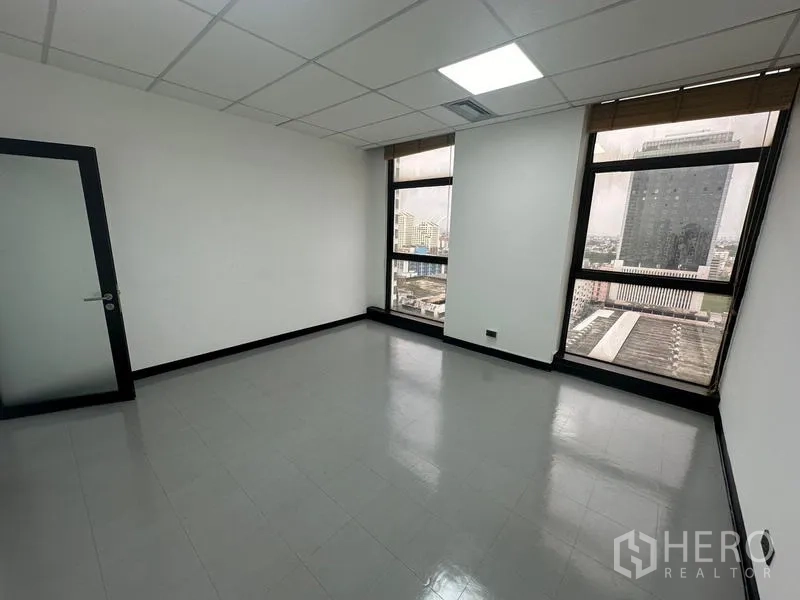 Office Space for rent - Bright office room with two windows and a frosted glass door.