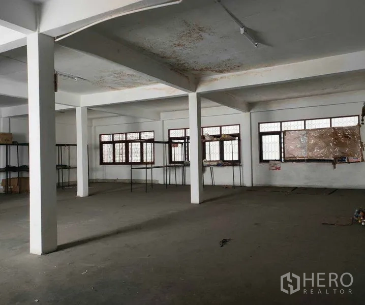 Shophouse for rent in Watthana, Bangkok - Large upper-floor open plan room with columns and windows suitable for office or storage.