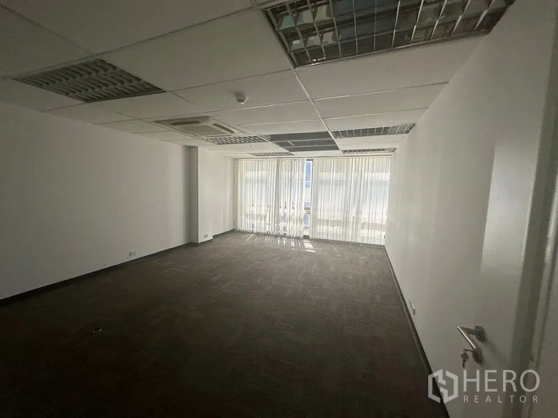 办公空间 出租在Khlong Toei, Bangkok - 长方形办公室，地毯砖、吊顶嵌入式空调与落地窗百叶。