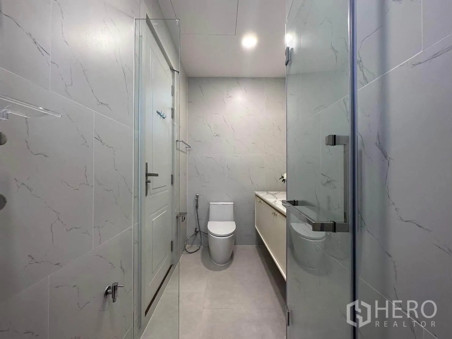 Detached House for rent in Saphan Sung, Bangkok - Clean bathroom with glass shower, toilet, and marble-style tiles.