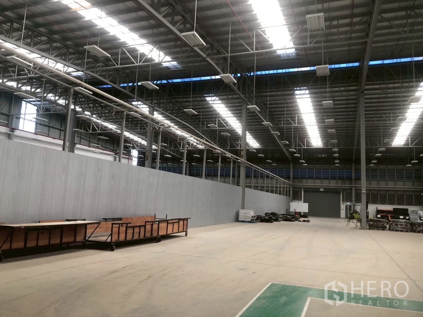 Factory for rent in Pluak Daeng, Rayong - Spacious warehouse interior with high steel truss roof, skylights, and open floor space.