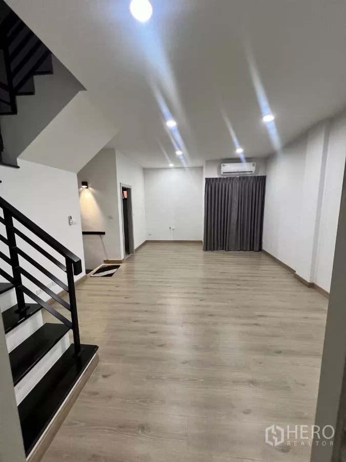 Home Office for rent in Lat Phrao, Bangkok - Open-plan room with wood flooring, staircase and air-conditioning, ideal for an office area.