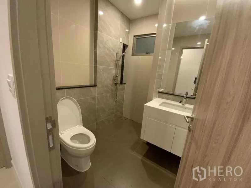 Townhouse for rent in Prawet, Bangkok - Guest bathroom with vanity, toilet and shower area.
