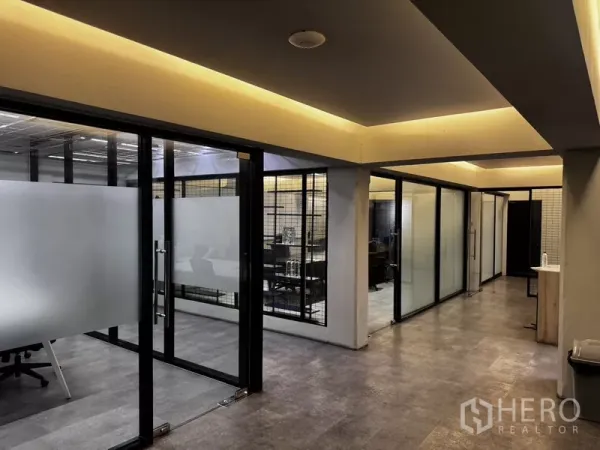 Office Space for rent or sale in Suan Luang, Bangkok - Corridor with glass-partitioned offices, frosted panels and warm ceiling lighting.