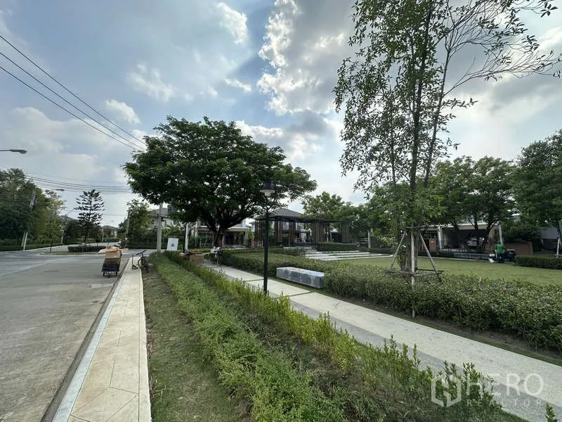 Detached House for sale in Sai Mai, Bangkok - Landscaped community walkway with greenery and seating areas.