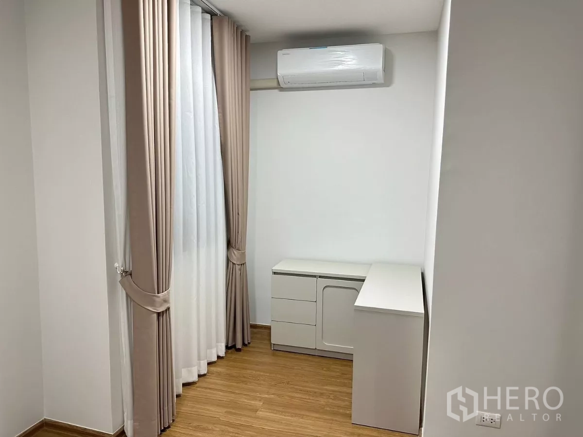 Townhouse for rent in Bang Phli, Samut Prakan - Compact study corner with desk, drawers and wall‑mounted air‑conditioner.