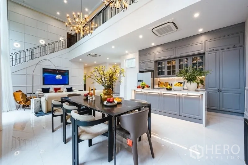 Detached House for sale in Bang Kapi, Bangkok - Open-plan double-volume living, dining and kitchen with balcony-style railing and recessed lights.