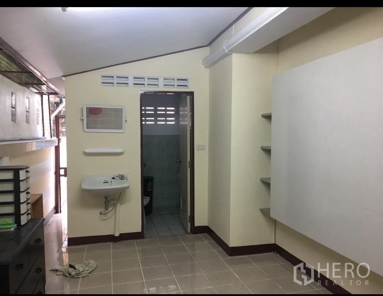 独立式住宅 出租在Min Buri, Bangkok - 多功能间，墙挂洗手盆、置物架与通往次卫的门。