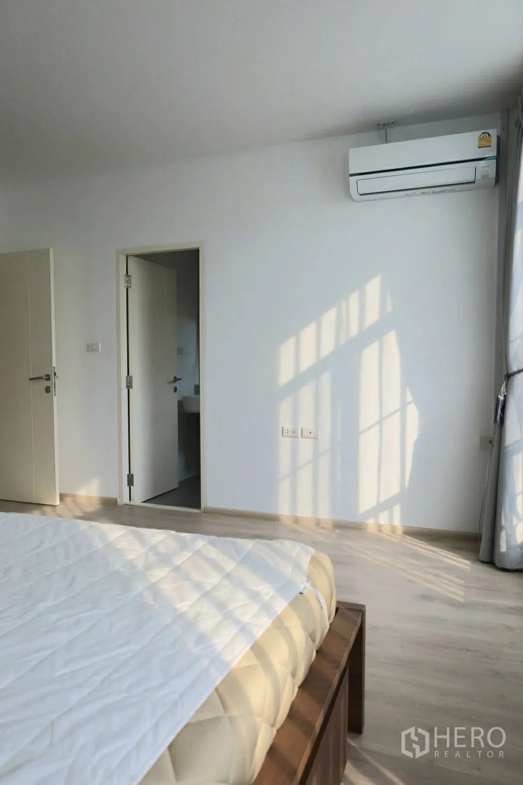 联排别墅 for rent in Prawet, Bangkok - 主卧采光充足，配空调、木地板，并带套内卫生间门。
