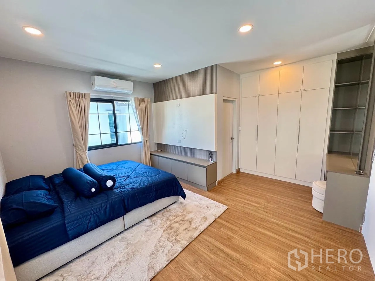 Detached House for rent in Bang Phli, Samut Prakan - Spacious bedroom with blue bedding, built-in wardrobes and TV wall.